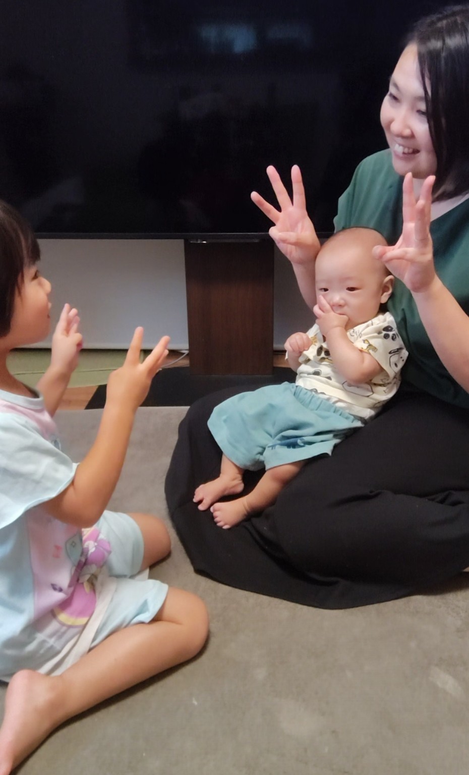 戸田まいこと子どもたちが3人で手遊びを楽しむ様子